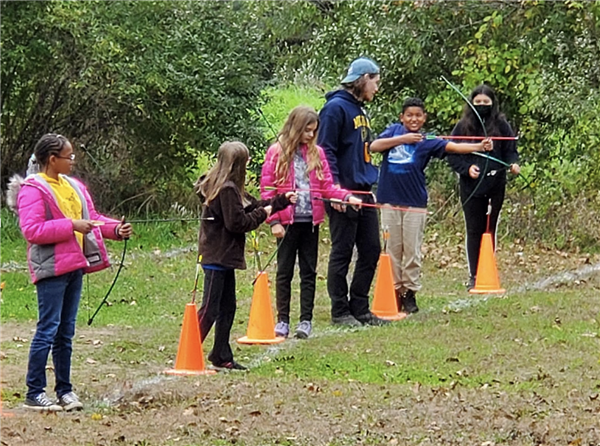 Students learning to use a bow and arrow.